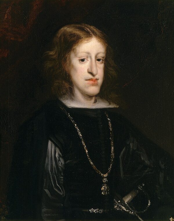 Portrait en pied d'un jeune roi au visage pâle et allongé, au menton proéminent, en habit noir à col de dentelle, la main posée sur une table.