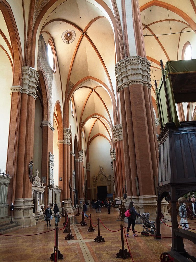 Intérieur d'une immense église gothique de briques ; au sol, une ligne de laiton traverse le dallage dans toute la longueur de la nef.
