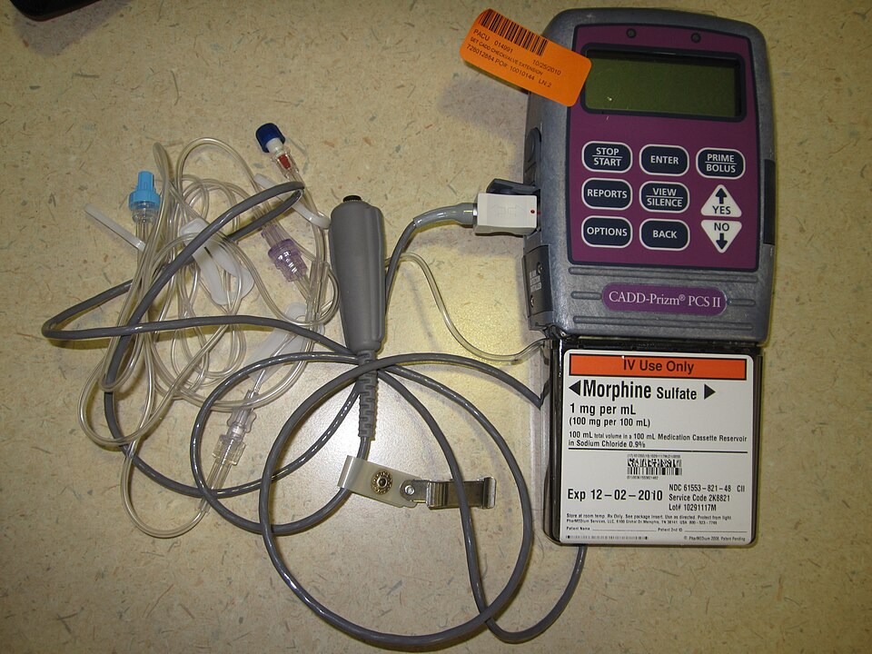 Pompe à perfusion électronique, avec écran et clavier, fixée sur un pied à perfusion