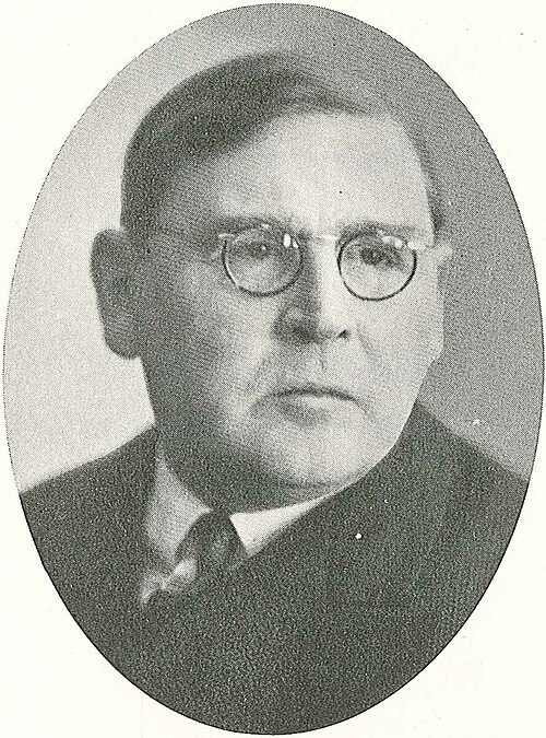 Portrait en médaillon d'Erik Widmark, homme d'âge mûr à lunettes rondes, en costume