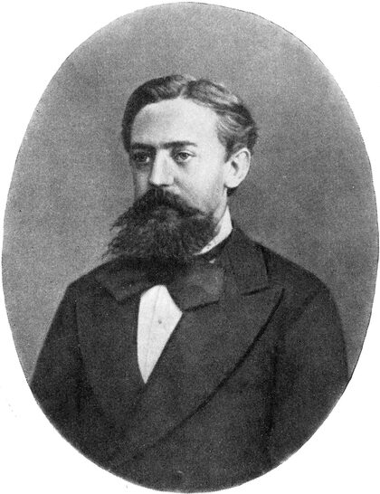 Portrait photographique d'Andreï Markov, homme barbu en costume sombre.