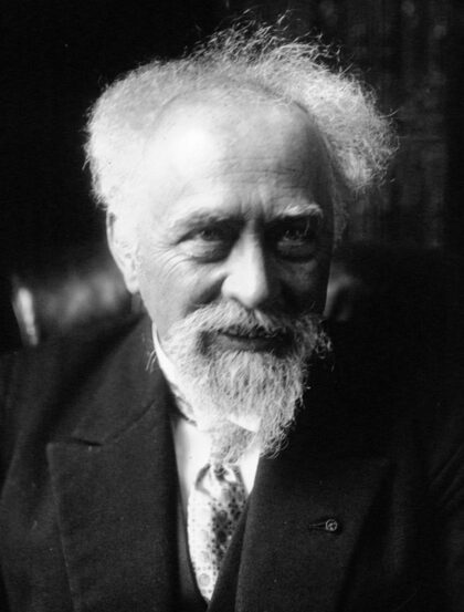 Photographie en noir et blanc de Jean Perrin, barbe et moustache, en costume.