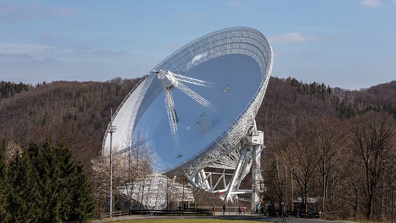 Le radiotélescope d'Effelsberg, une parabole blanche de cent mètres de diamètre dans une vallée boisée.