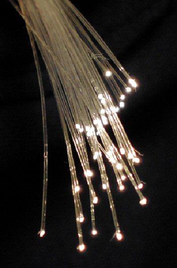 Un faisceau de fibres optiques fines dont les extrémités brillent de points lumineux.