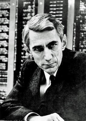 Photographie en noir et blanc de Claude Shannon, homme âgé aux cheveux blancs, souriant, en veste.